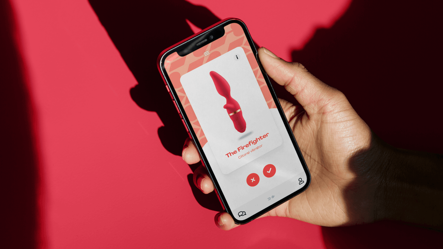 Hand holding smartphone over red background showing an app product page for a pink vibrator.