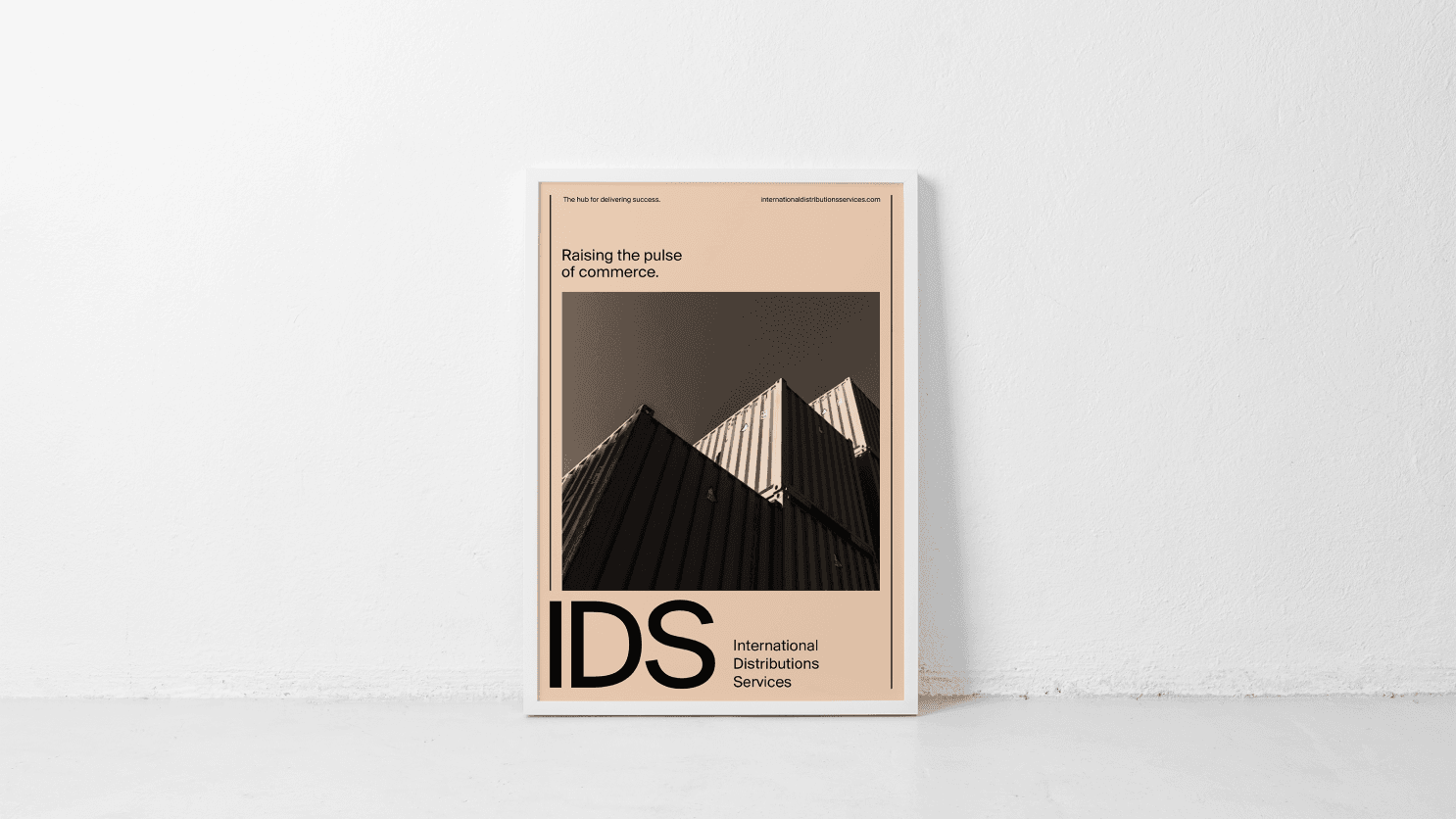 Framed minimalist poster leaning against a white wall, showing a geometric black-and-white building photo with bold "IDS" branding.