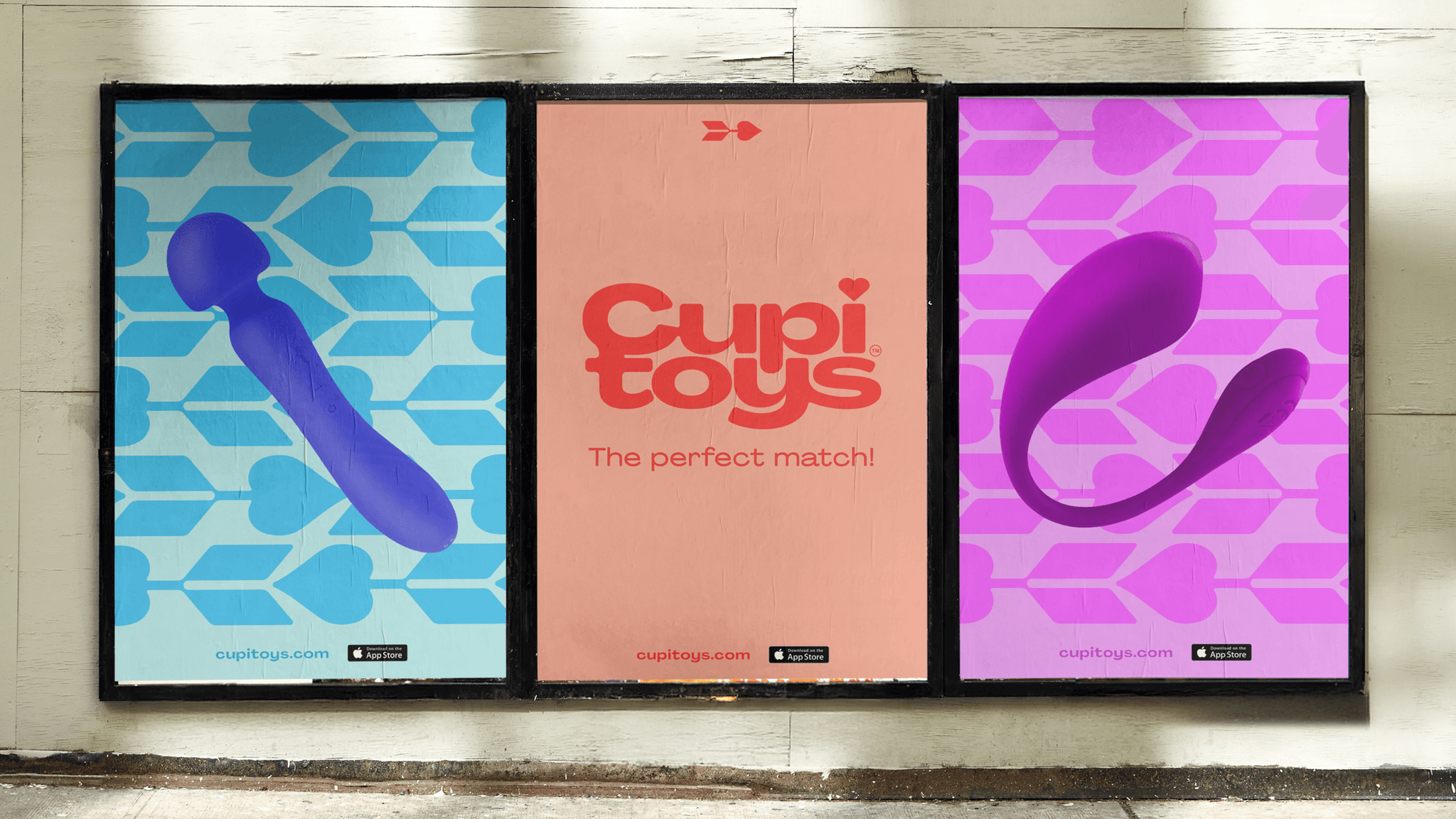 Three-panel street ads for "CupiToys": center salmon panel with logo "The perfect match!"; left blue panel with a purple vibrator silhouette; right pink panel with another vibrator.