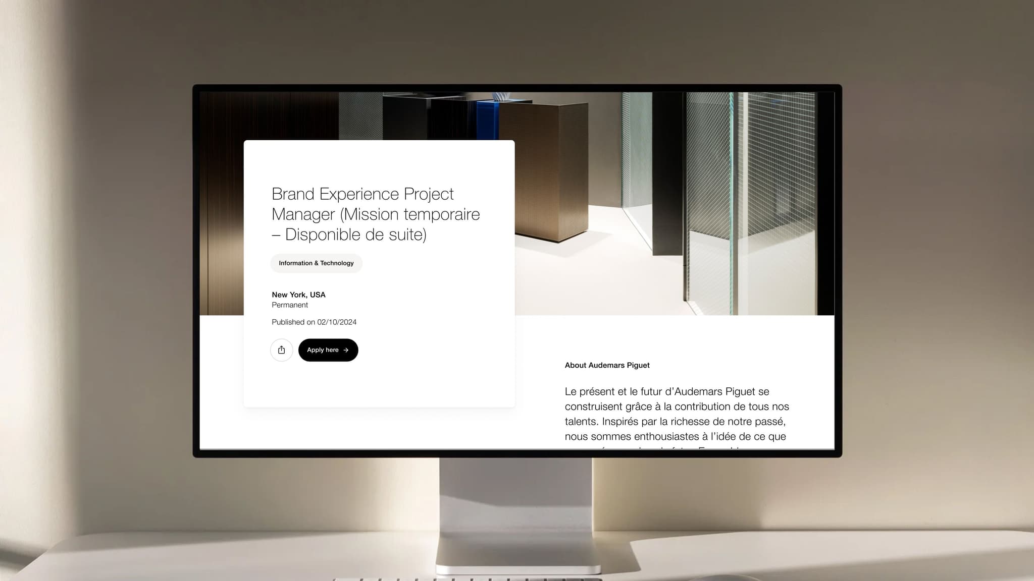 Wide desktop monitor on a minimalist desk displaying a French job listing for 'Brand Experience Project Manager' with white info panels.