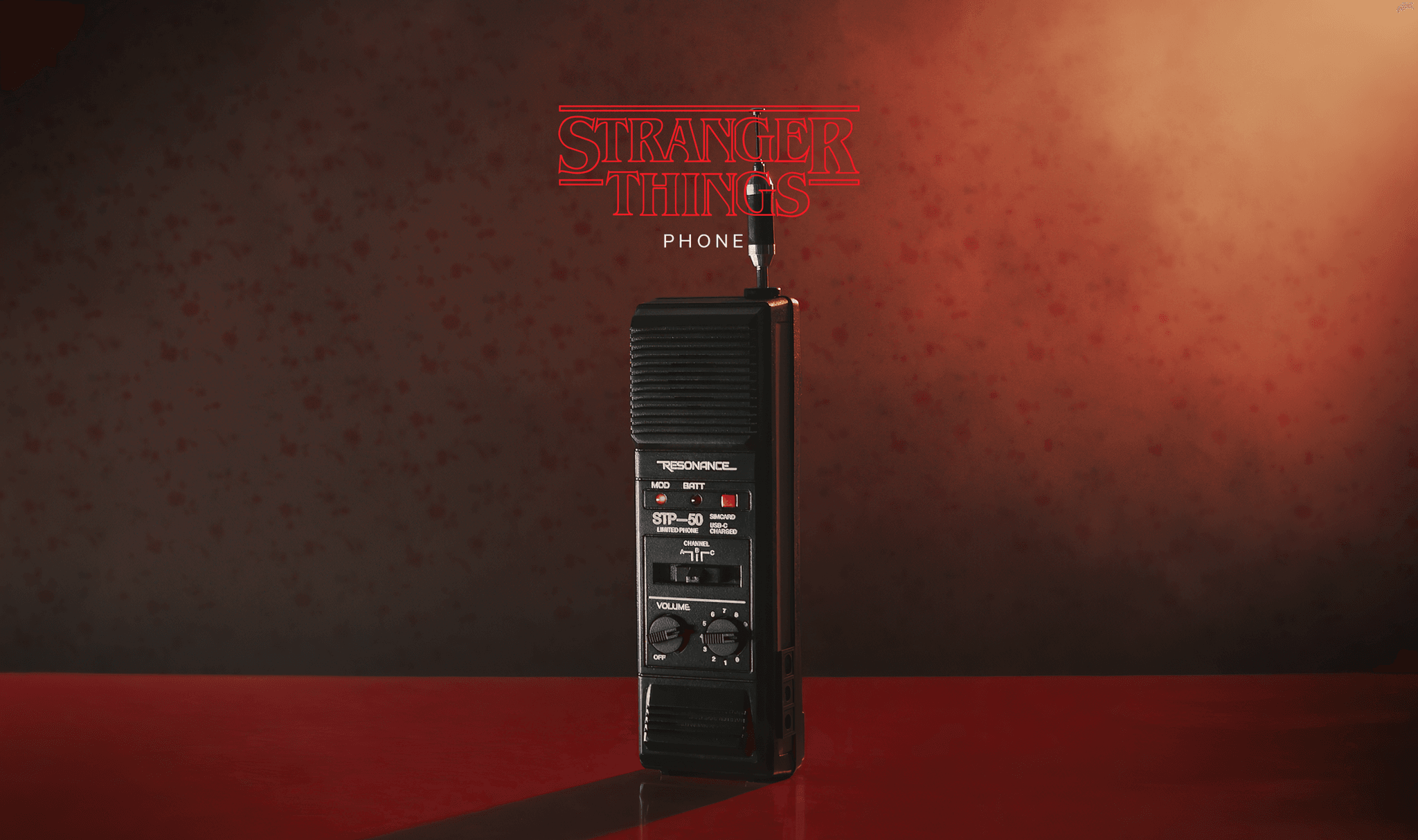 Tall black retro brick phone prop with knobs on a glossy red surface, "Stranger Things" logo displayed above. This is the same phone used across the Stranger Things show.